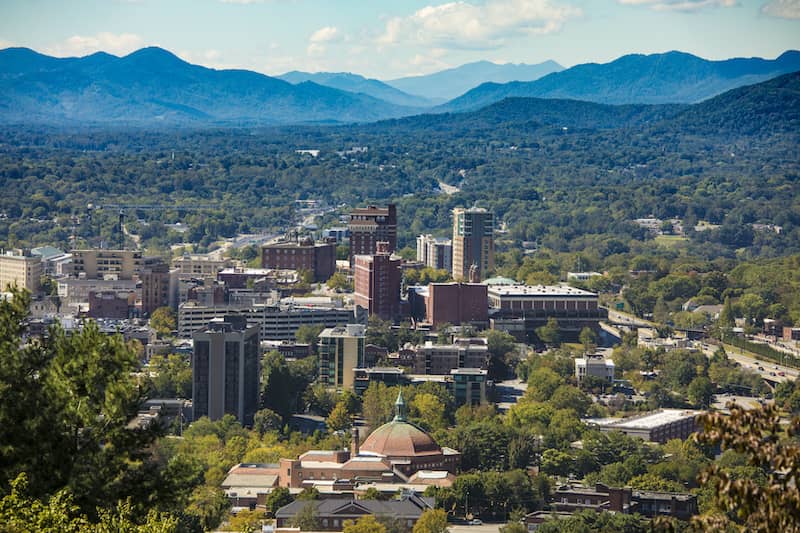 RHB Assets From IGX: Scenic view of Asheville, North Carolina, surrounded by lush greenery and mountains.