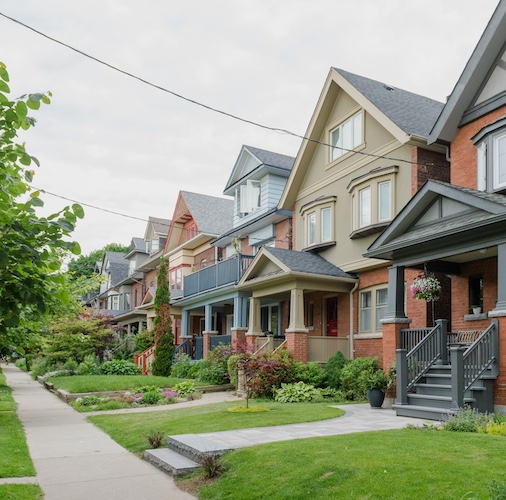 Row of homes in an older neighborhood on tree lined street.