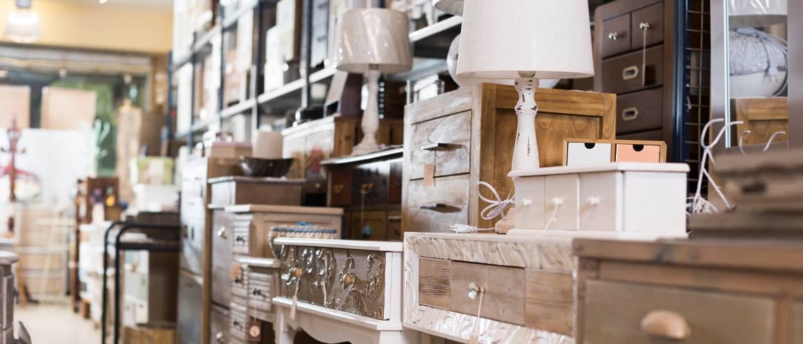 RHB Assets From IGX: Long line of assorted wooden furniture in a bright showroom.