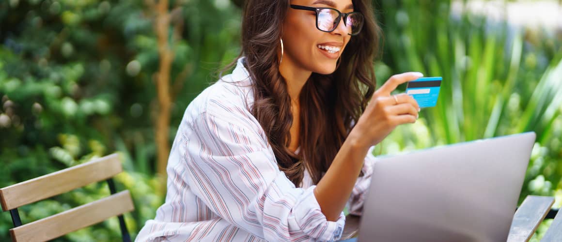 RHB Assets From IGX: A woman using a credit card on a laptop.