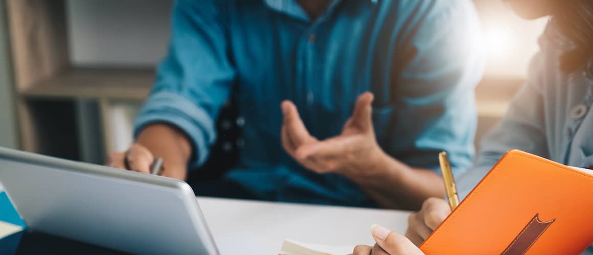 A man potentially explaining real estate or taxes to a female from an iPad.