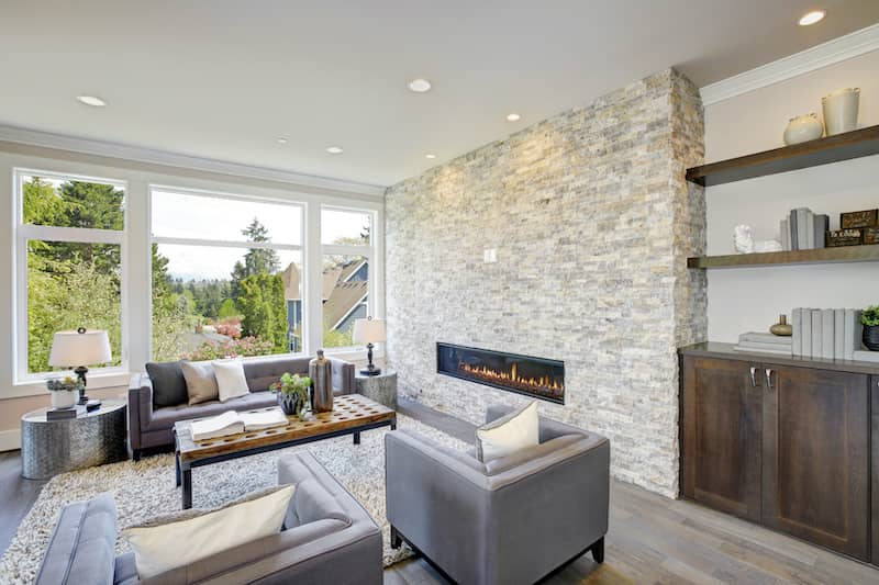 RHB Assets From IGX: A contemporary living room with a natural stone accent wall.