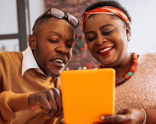 A man and women discussing something on a tab.