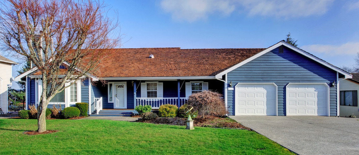 A blue ranch-style house with white trim, showcasing a residential property.