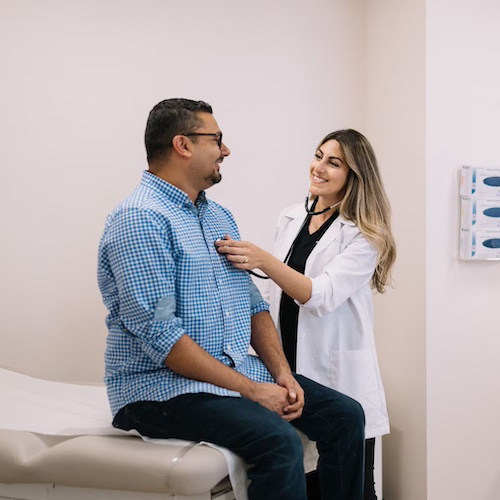 Middle-aged man chats with doctor at a check-up.