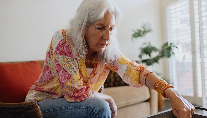 Woman sitting on couch playing chess.