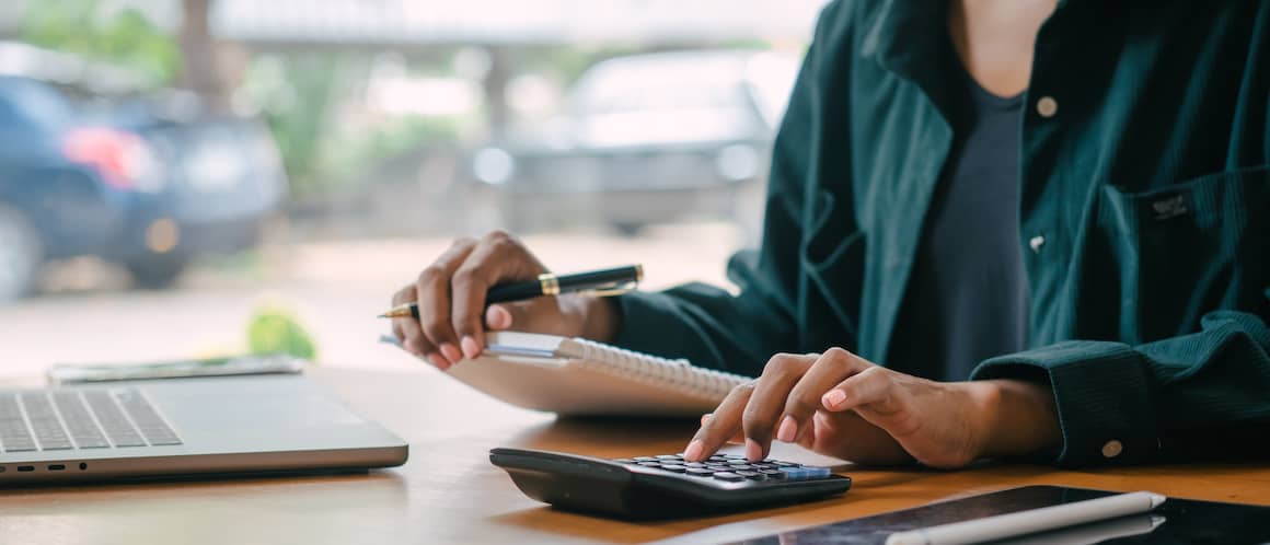 A woman using a calculator, possibly related to financial or real estate calculations.