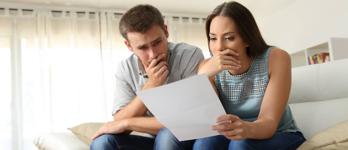 RHB Assets From IGX: Worried couple reading a letter at home