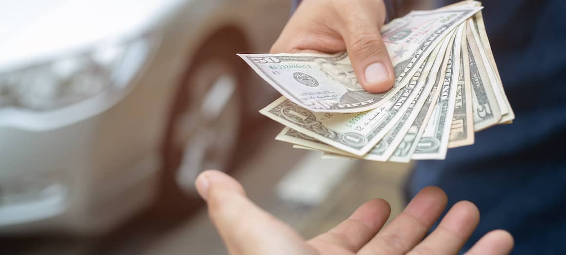 A close-up of a person handing money to someone else.