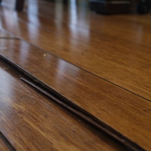 Closeup of uneven wooden floor in old home.