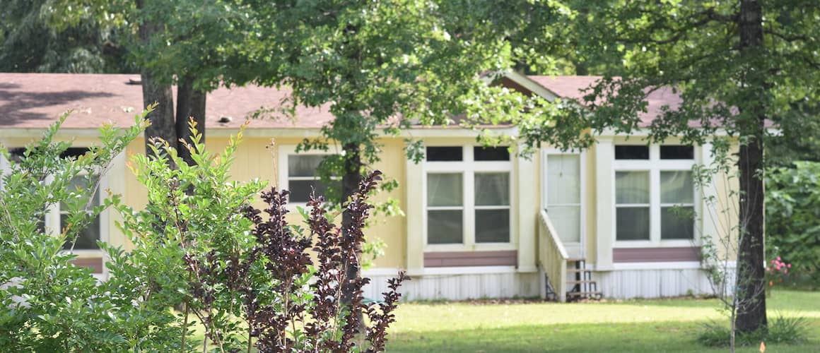 A manufactured home in springtime surroundings, possibly in a suburban area.