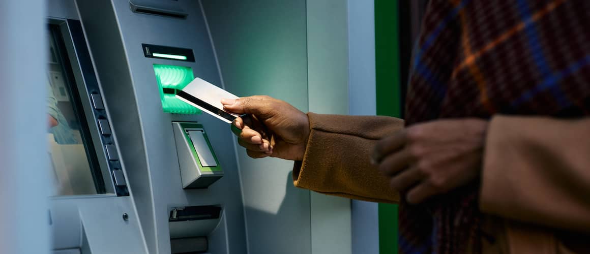 Close up of woman withdrawing money from ATM.