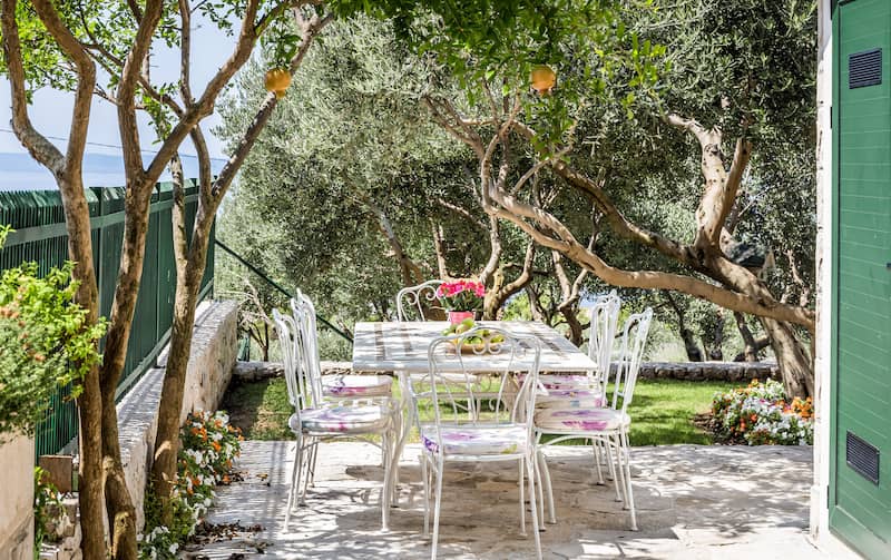 RHB Assets From IGX: Elegant Mediterranean-style patio with outdoor furniture and lush plants