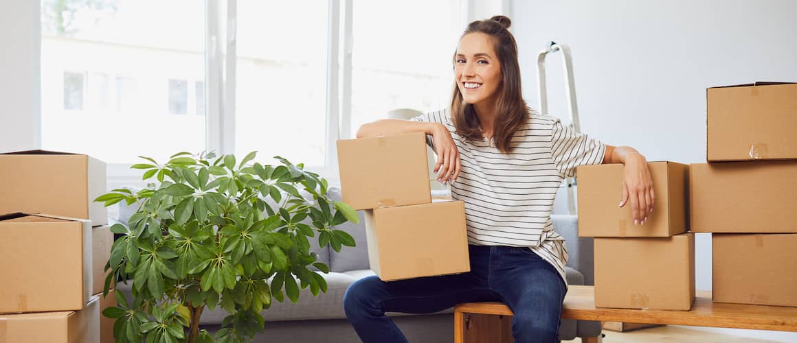 Woman moving into an apartment, representing relocation or housing change.