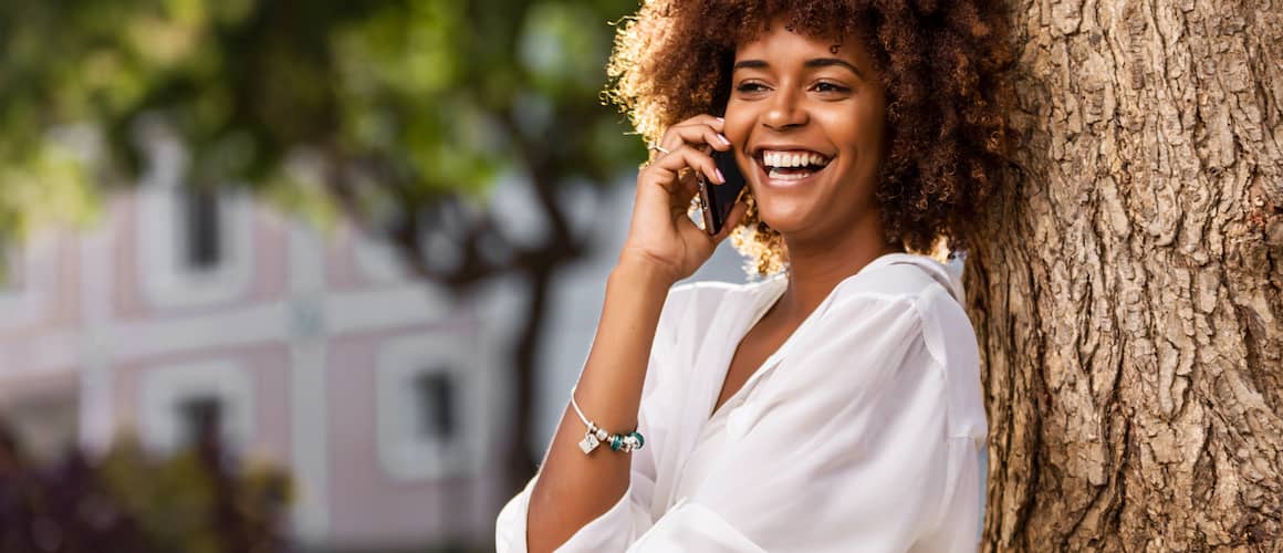 Young woman smiling, on phone.