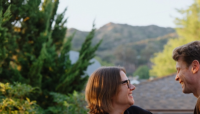 Couple holding hands on porch smiling.