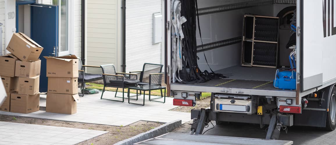 Moving truck being filled with boxes and belongings, indicating a relocation process.