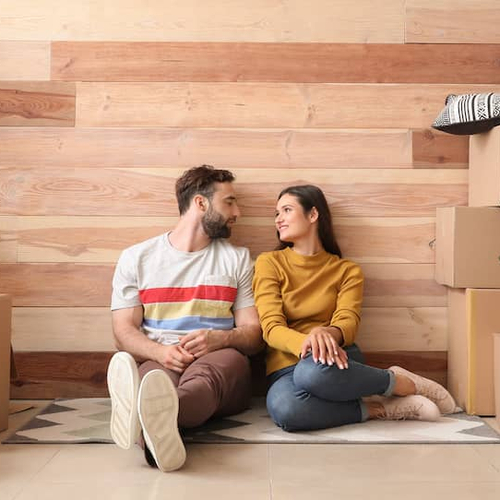 A couple inside a new house, engaged in the unpacking process.