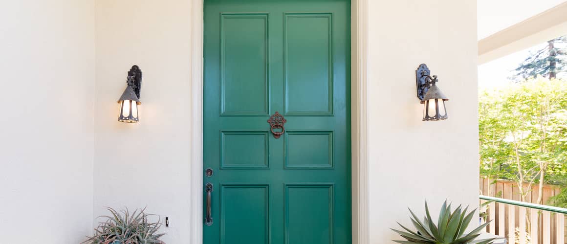 RHB Assets From IGX: Close-up of a green door with a shiny brass handle and an elegant design.