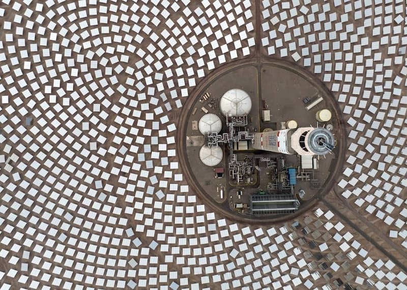 Aerial view of solar panels concentrated in circular formations around a convertor.