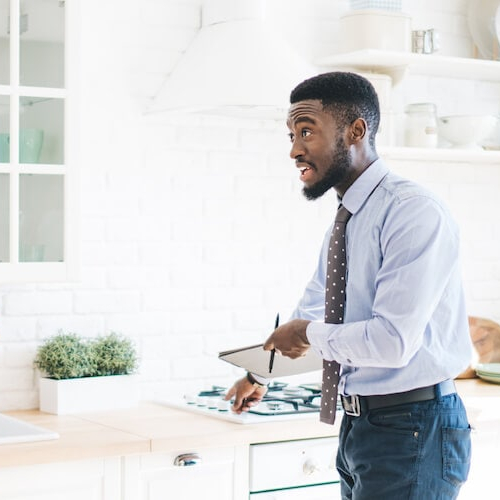 A couple with a realtor examining a new kitchen space in a property.