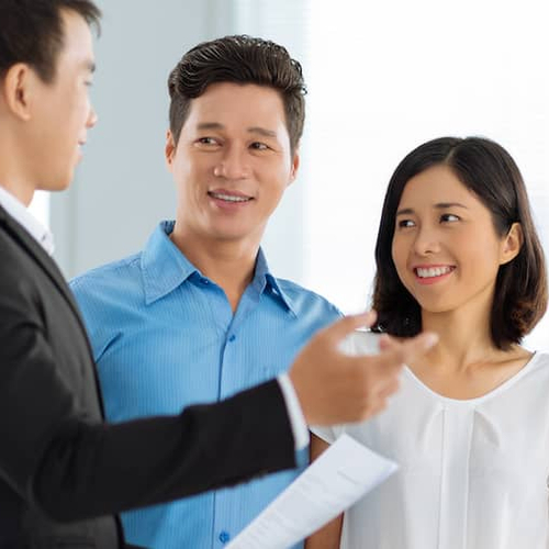A realtor showing a house to a couple, potentially in a residential setting.