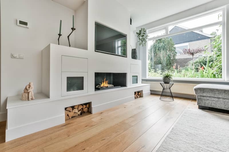 Modern living room with gray furniture and bright light coming from a large window.