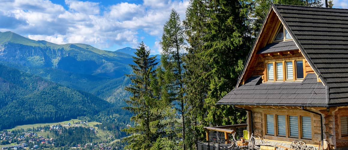 A rural cottage nestled in the mountains, suggesting a serene and remote living environment.