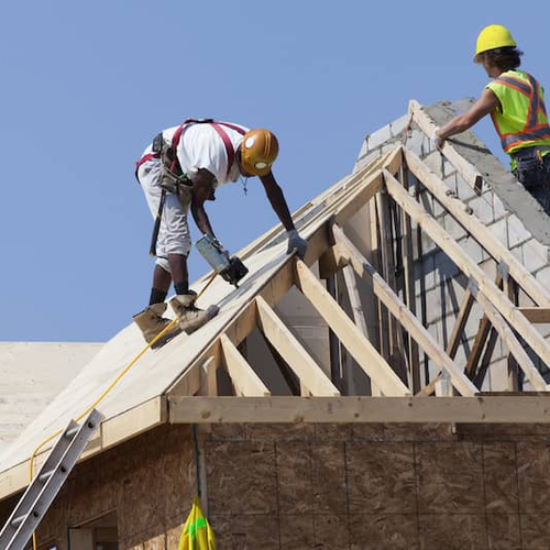 Workers on a building roof, possibly involved in construction or maintenance work.