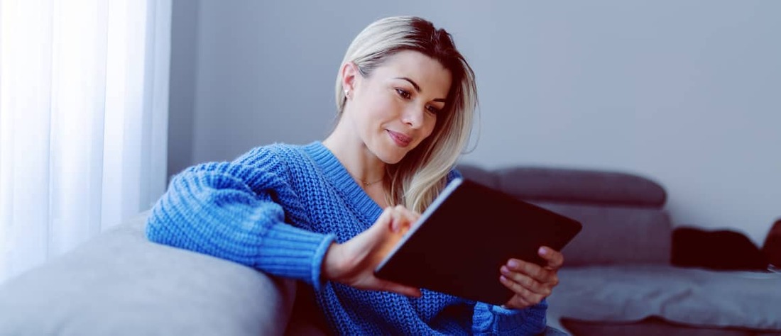 Woman checking credit score on tablet.