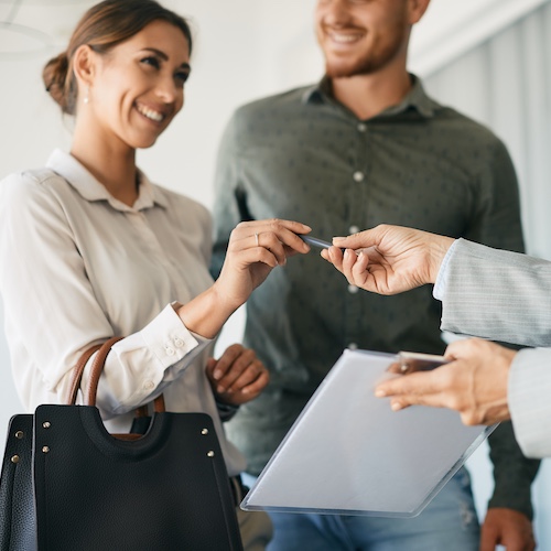 Couple signing papers to close on a home.