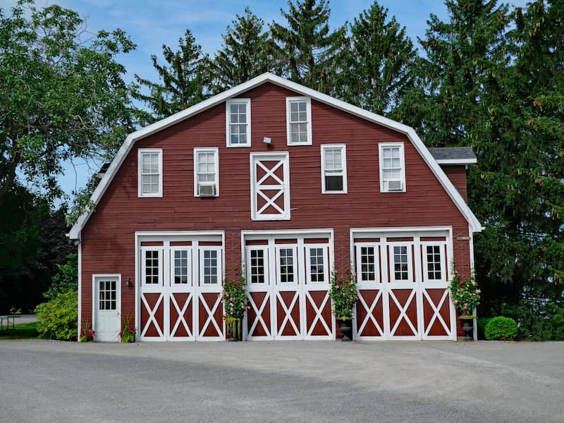 Two story barn with three large doors with glass panels.