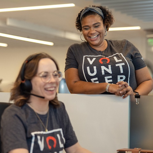 Two women in the office chatting during National Disability Awareness month.