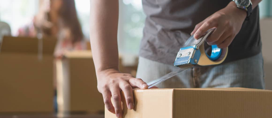 RHB Assets From IGX: A man taping a box in preparation for moving