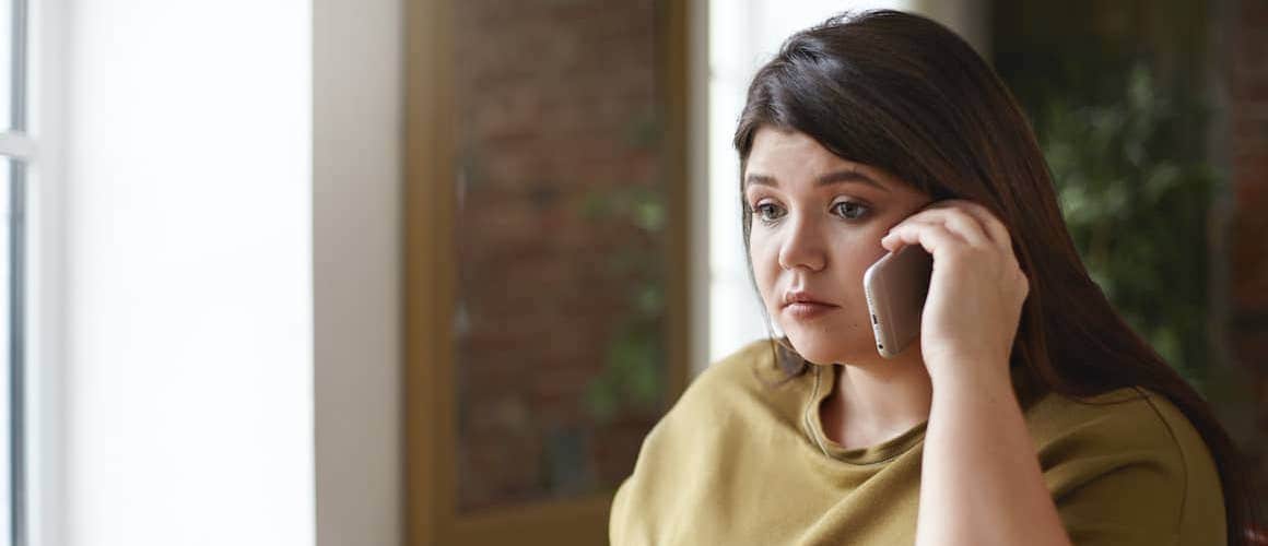 A worried woman on a phone who probably just heard a concerning news.