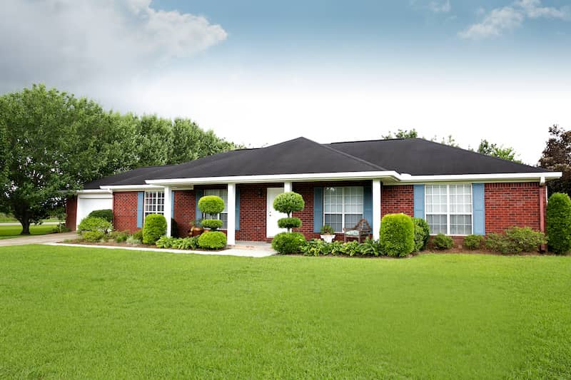 Brick ranch-style house with large front yard.