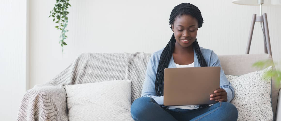 Young African-American woman using computer to check credit score.