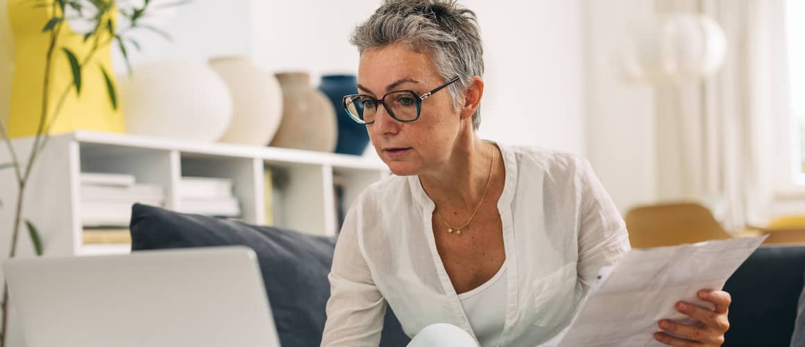 Elderly woman doing taxes at home