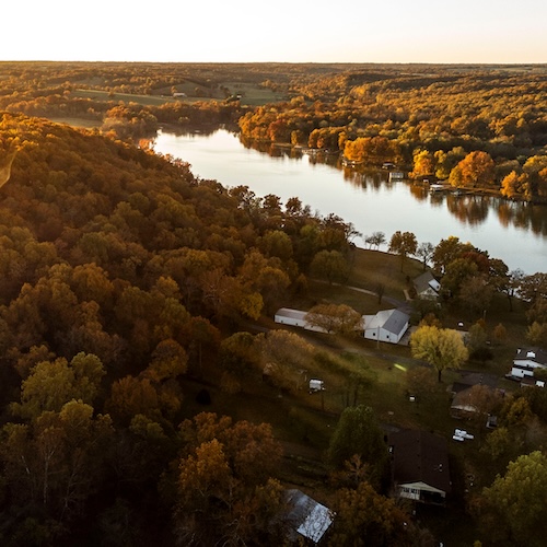 Aerial view of houses along a lake in Oklahoma during an autumn sunset.