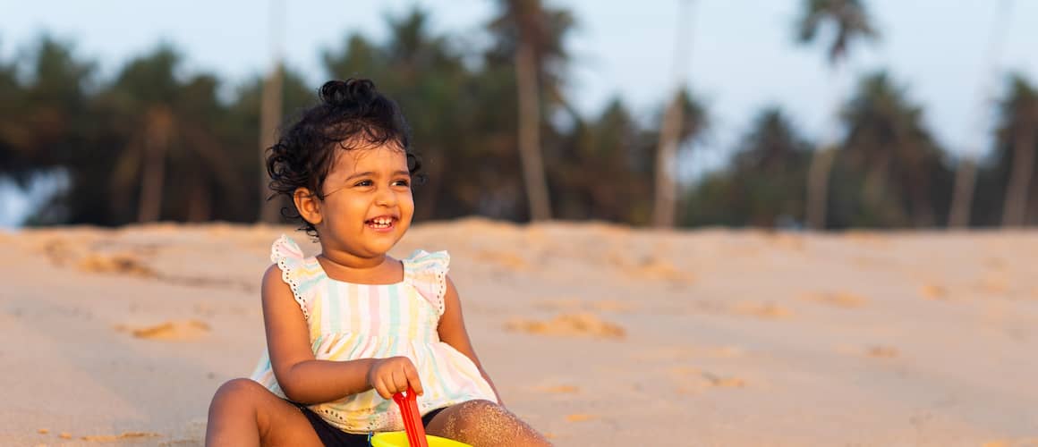 A baby at the beach, likely an image emphasizing family leisure or vacation homes.