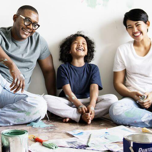 Family engaging in a painting activity, possibly related to home improvement or creative bonding.