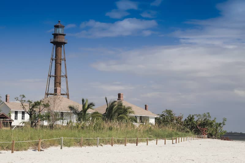 RHB Assets From IGX: Sanibel Island Lighthouse in Florida, surrounded by lush greenery and a blue sky.