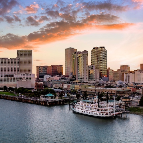 New Orleans river cityscape with a large paddlewheel boat.