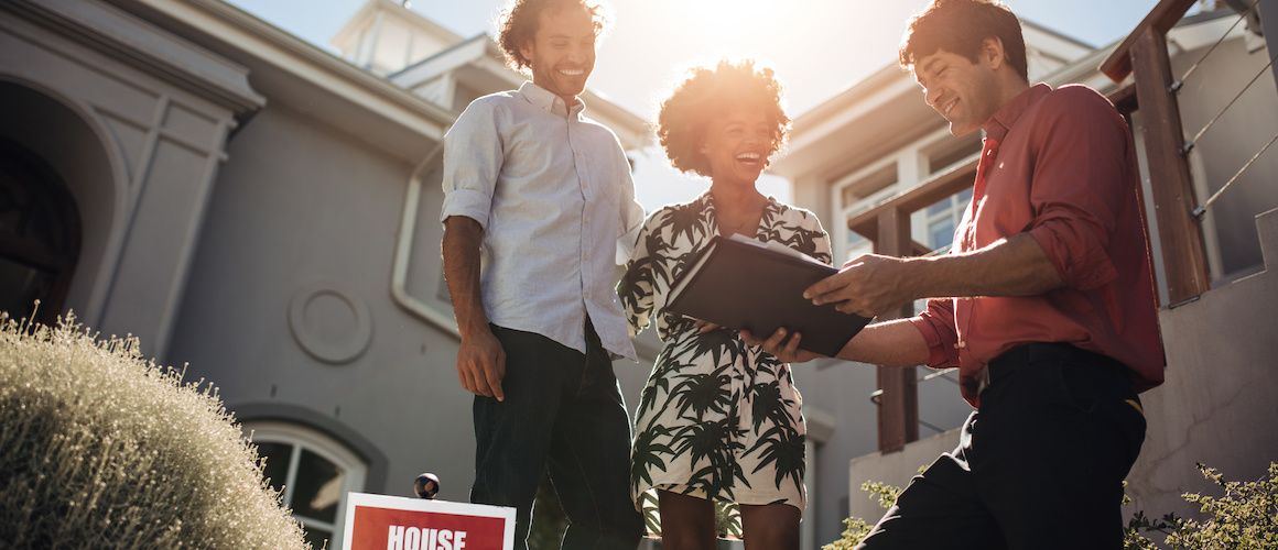 A couple with an agent in a home, likely discussing real estate matters.