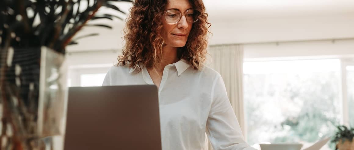 Woman going over paperwork and having coffee.