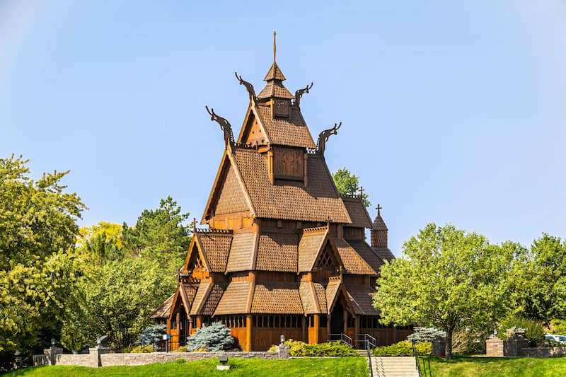 RHB Assets From IGX: Traditional Norwegian Stave Church in Minot, North Dakota surrounded by trees.