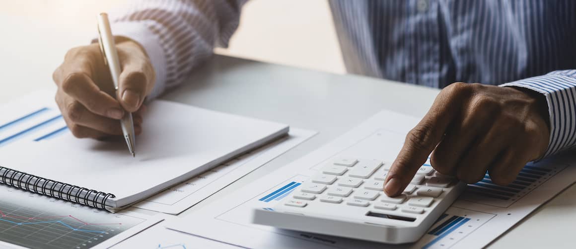 RHB Assets From IGX: Man sitting at a table, calculating finances and reviewing paperwork.