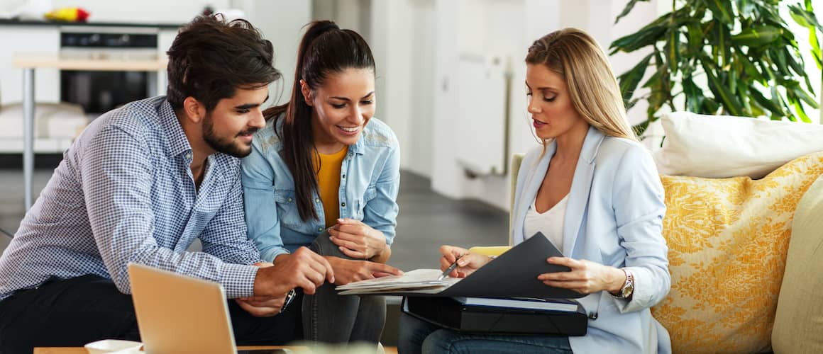 RHB Assets From IGX: Professional insurance agent explaining a policy to a client in an office.