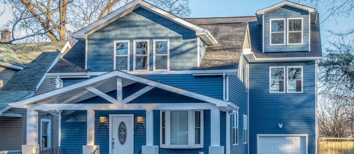 Large blue craftsman house with white trim.