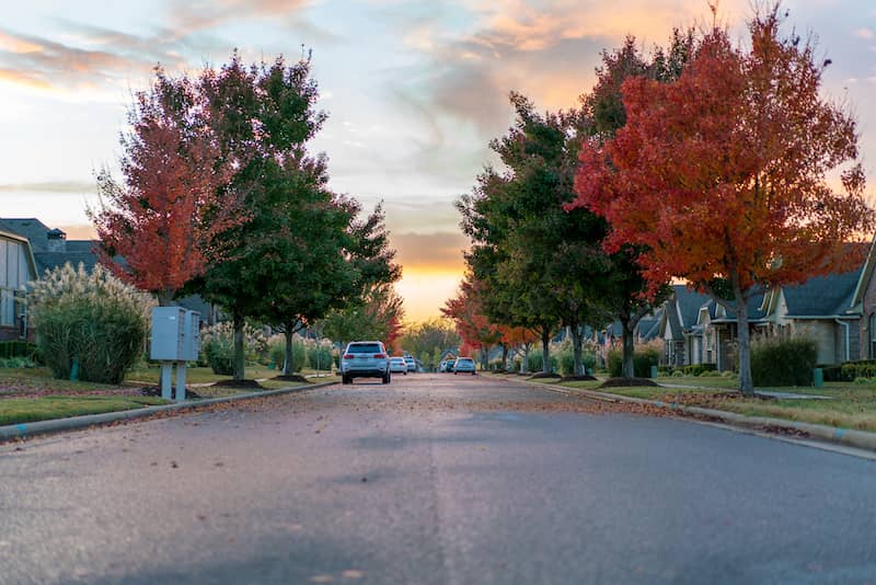 RHB Assets From IGX: Residential street at sunset in Bentonville, Arkansas with manicured lawns.